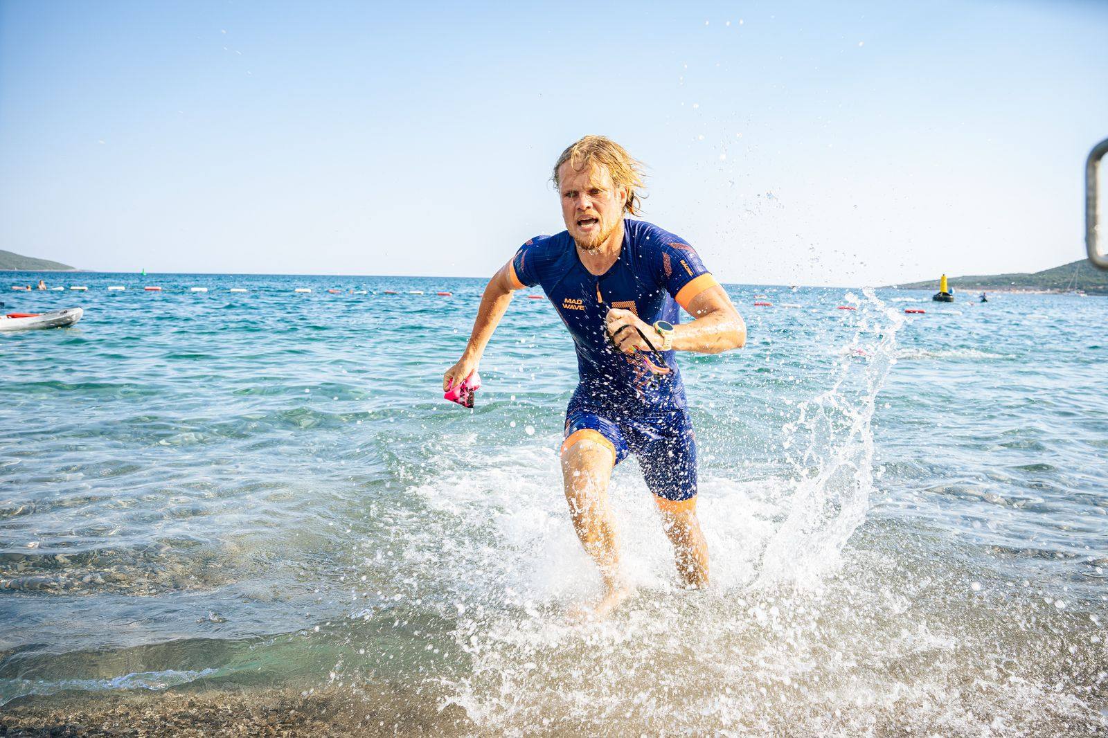 Triathlète sortant de l'eau en pleine course lors d'une épreuve de triathlon, gouttes et mouvement